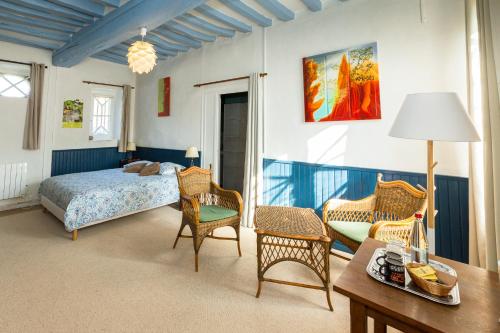 - une chambre avec un lit, des chaises et une table dans l'établissement Auberge du Manoir d'Archelles, à Arques-la-Bataille