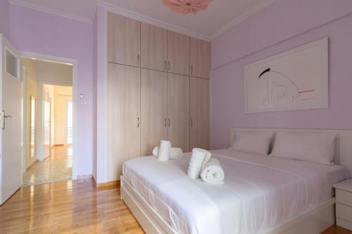 um quarto com uma cama branca e toalhas em Bright and Spacious 2-bedrooms Apartment in Athens em Atenas