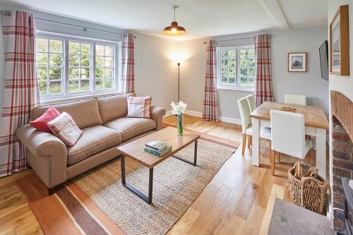 sala de estar con sofá y mesa en Host & Stay - Gardeners Cottage, en Brafferton