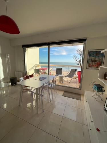une salle à manger avec une table et une vue sur l'océan dans l'établissement Malibu Beach LA BAULE appartement face à la mer !, à La Baule
