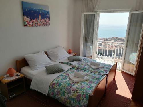 a bedroom with a bed and a large window at Guest House Blaise in Dubrovnik