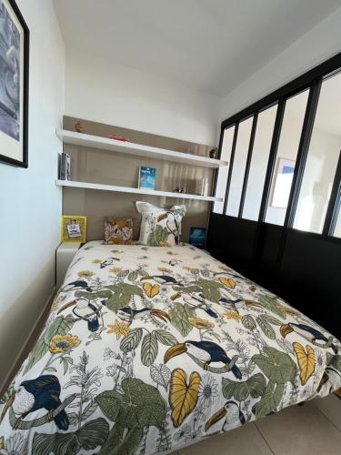 a bedroom with a large bed with a colorful blanket at Malibu Beach LA BAULE appartement face à la mer ! in La Baule