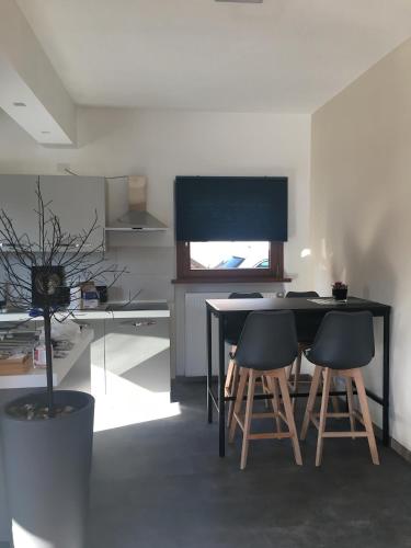 a kitchen with a black table and two stools at Appartamento Carducci in Pieve di Cadore