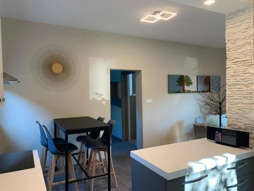 a kitchen with a black table and chairs at Appartamento Carducci in Pieve di Cadore