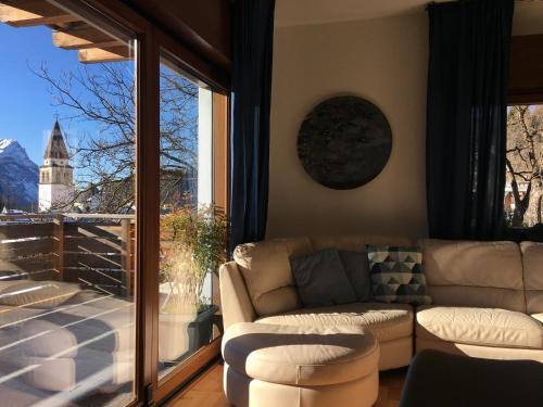 a living room with a couch and a large window at Appartamento Carducci in Pieve di Cadore