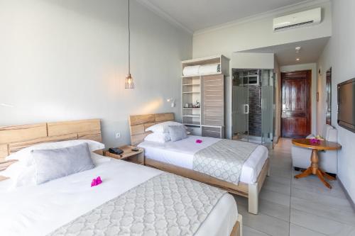 a bedroom with two beds and a kitchen at Le Peninsula Bay Beach Resort & Spa in Blue Bay