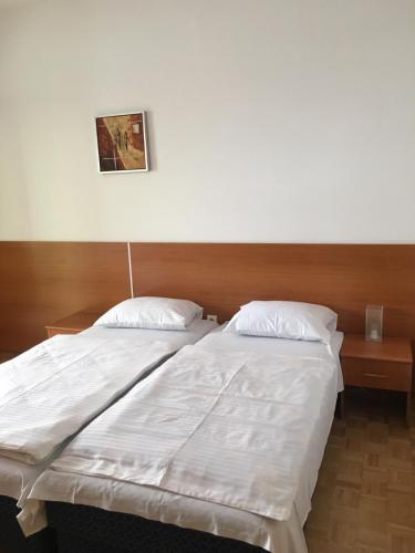 a large white bed with two pillows on it at Solar Apartments in Herceg-Novi