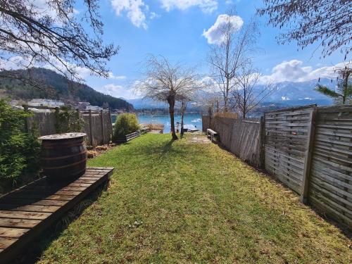 a backyard with a fence and a field of grass at Apartment am Faaker See in Egg am Faaker See