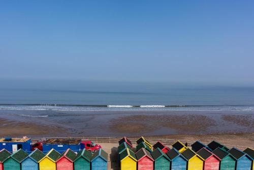 a row of colorful beach huts on the beach at La Rosa Hotel in Whitby