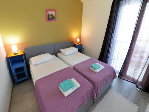 a bedroom with two beds and two lamps on tables at Apartments Helena in Murter