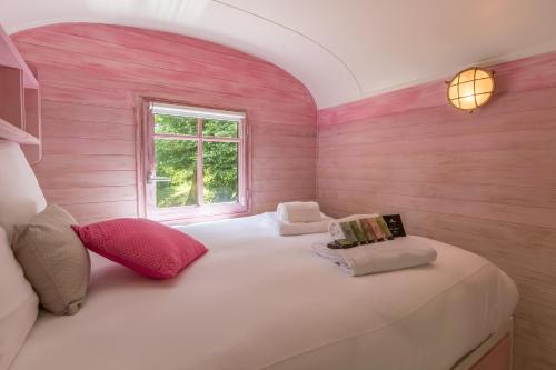 a room with two beds with pink walls and a window at Locations - Domaine Le Coq Enchanté in Cambremer