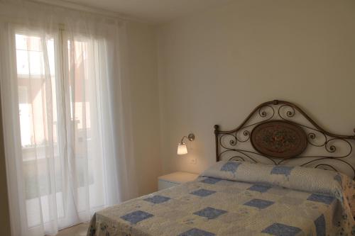 - une chambre blanche avec un lit et une fenêtre dans l'établissement Luisa bilocale con giardino, à Castagneto Carducci