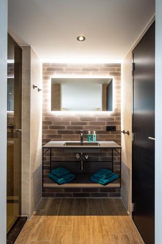 a bathroom with a sink and a mirror at Slow Down Texel in Den Burg