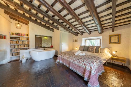 a bedroom with a large bed and a bath tub at Masia Marco Lux, ideal familias con gran zona exterior y Piscina in Llagostera