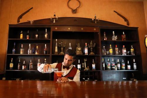 a man preparing a drink at a bar at Bandarawela Hotel in Bandarawela