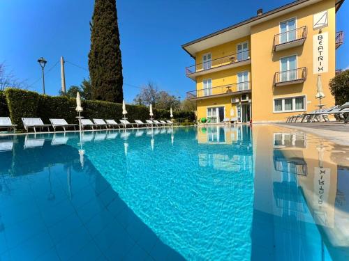 a swimming pool in front of a building at Residence Beatrix in Bardolino