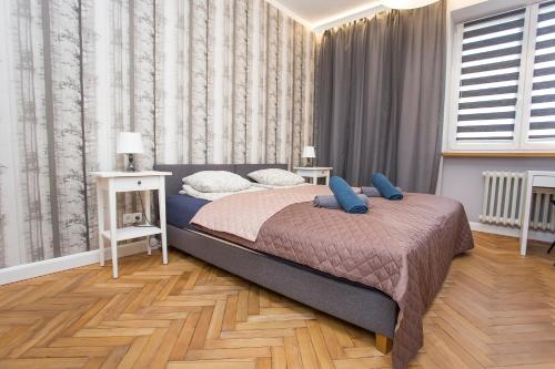 a bedroom with a bed with blue pillows on it at Urban Jungle apartment in the heart of the city in Białystok