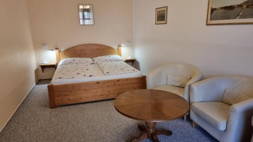 a bedroom with a bed and two chairs and a table at Pension Rondel in Poděbrady
