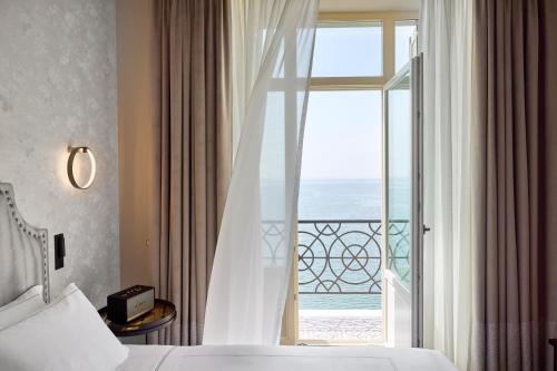 a bedroom with a window with a view of the ocean at ON Residence in Thessaloniki