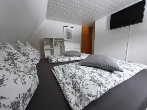 a bedroom with two beds with pillows and a flat screen tv at Ferienhaus Erzgebirge in Marienberg