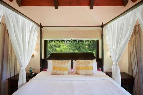 a bedroom with a large bed with a window at Vannraj Resort And Spa in Khawāsa