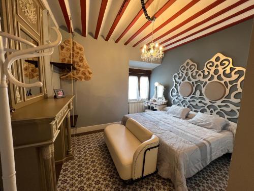 a bedroom with a large bed and a chandelier at Retiro del Teatro Almagro in Almagro