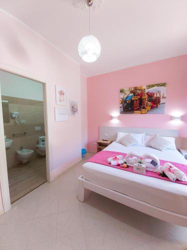a pink bedroom with a bed with stuffed animals on it at Le Twins -Bed and Breakfast in Tropea