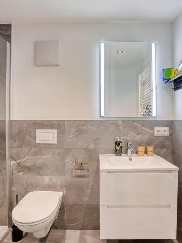 a white bathroom with a toilet and a sink at Limehome Zwickau Hauptmarkt in Zwickau