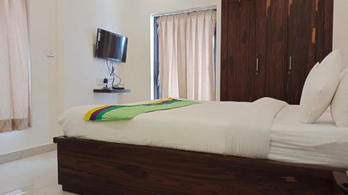 a bedroom with a large bed with a television on it at PARKSTONE in Kolkata