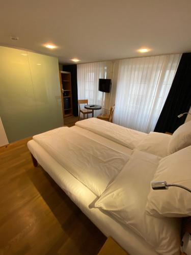 a large white bed in a hotel room at Hotel Lestelle - self check-in in Luzern