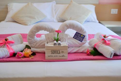 a bed with towels and a sign that says smile at Le Twins -Bed and Breakfast in Tropea