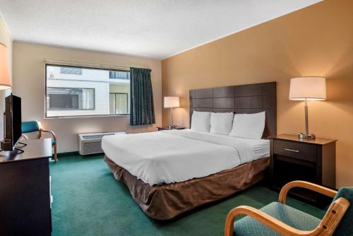 Un pat sau paturi într-o cameră la Rodeway Inn & Suites