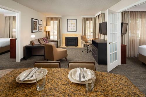 Habitación de hotel con mesa de comedor y sala de estar. en Sonesta ES Suites Nashville Brentwood, en Brentwood