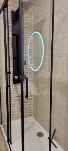 een douche met een ronde spiegel in de badkamer bij Chambre La Palmeraie village naturiste in Cap d'Agde