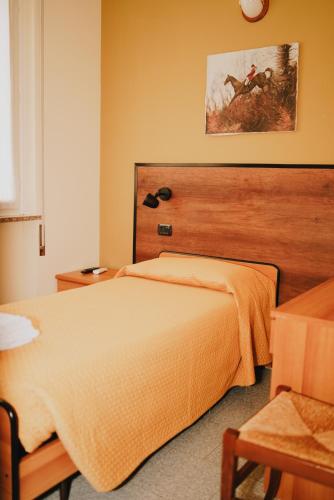 a bedroom with a large bed with a wooden headboard at Locanda La Castellana in Castello d'Agogna