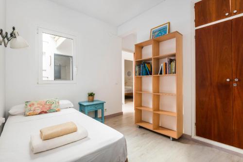 a bedroom with a bed and a book shelf at Caseta Diana - Alcaufar in Sant Lluis