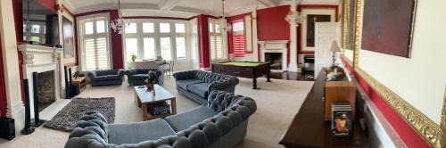 a large living room with couches and a piano at Trawscoed Mansion,Central Wing in Aberystwyth