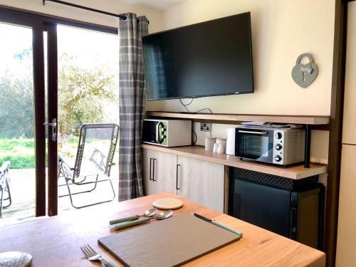 a living room with a table with a tv and a table sidx sidx at Woolston lodge in Oswestry