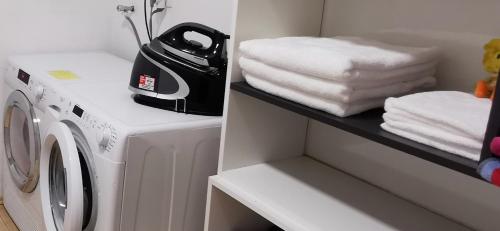a laundry room with a washing machine and towels at Casa M in Lopatinec