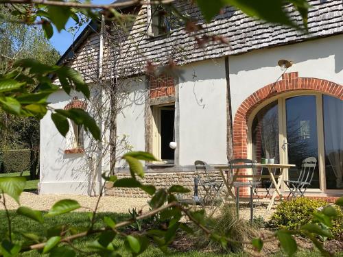 a small white house with a table and chairs at Locations - Domaine Le Coq Enchanté in Cambremer