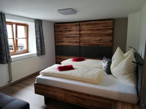 1 dormitorio con 1 cama con 2 almohadas rojas en Apart Burgstall, en Arzl im Pitztal