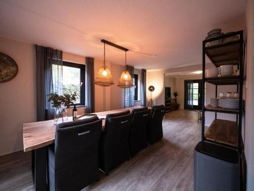 ein Esszimmer mit einem langen Tisch und Stühlen in der Unterkunft Villa BOSgeluk, riante rust bij BOS7 op de Veluwe. in Putten