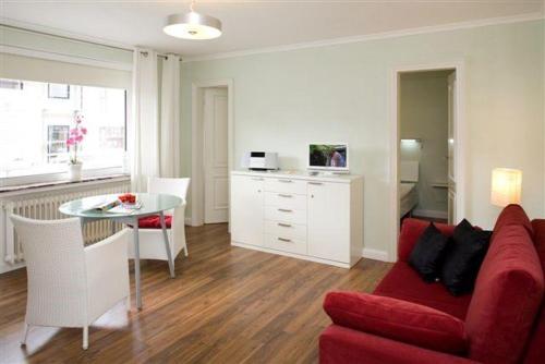 ein Wohnzimmer mit einem roten Sofa und einem Tisch in der Unterkunft Mar2 6 Strandkoenig 7 in Westerland