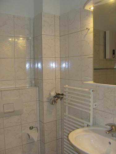 ein weißes Bad mit einem Waschbecken und einer Dusche in der Unterkunft Mar2 6 Strandkoenig 7 in Westerland