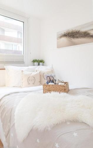 ein weißes Schlafzimmer mit einem weißen Bett und einer weißen Decke in der Unterkunft Carmen Sylva 11 (Dün12 - 11) in Westerland