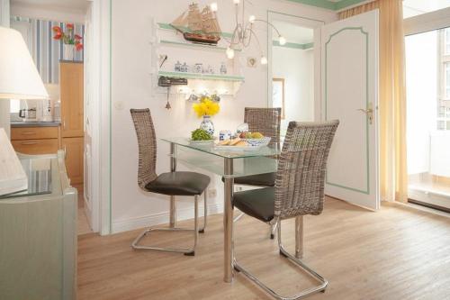 ein Esszimmer mit einem Tisch und Stühlen in einer Küche in der Unterkunft Duen12_ 9 in Westerland