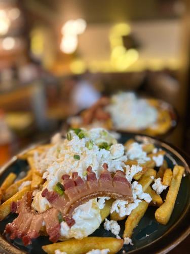 a plate of french fries with bacon and cheese at Casa Mignon in Oradea