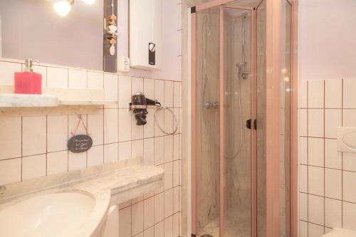 ein Bad mit einem Waschbecken und einer Dusche in der Unterkunft Duen12_ 9 in Westerland