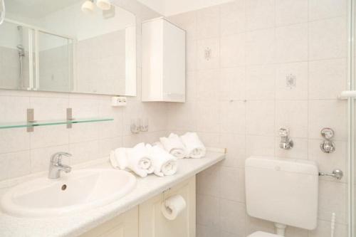 a white bathroom with a sink and a toilet at F23 App 25 Kurt S Island in Westerland (Sylt)