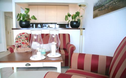 - un salon avec une table et deux vases dans l'établissement Ocean Hunter _S27 _ 27_, à Westerland